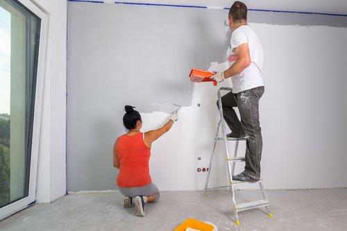 Construction- a couple painting a wall-1